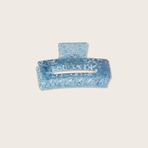 Pince à griffe bleue Pixie Woo pour cheveux, outil de coiffure élégant et pratique, visible en gros plan.