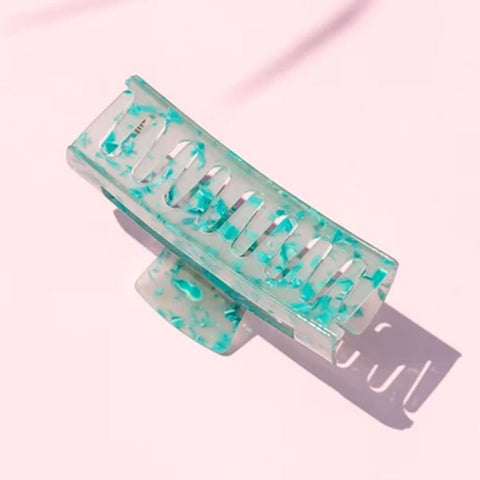 Pince à griffe turquoise Pixie Woo pour cheveux, finition élégante, visible dans l’image.