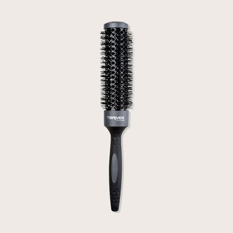 Brosse thermique circulaire Dannyco EVOXL 32 mm, outil pour coiffure, tube extra-long, en action sur des cheveux.