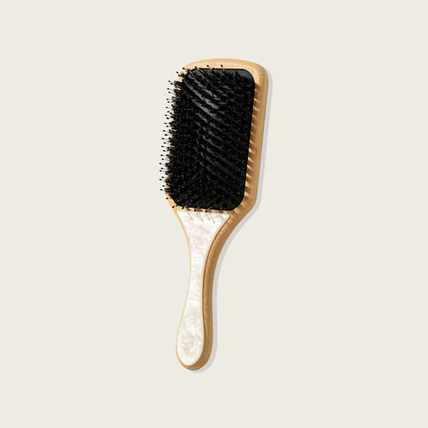 Brosse à cheveux rectangulaire blanche perle Pixie Woo pour brillance, design élégant et poignée ergonomique.