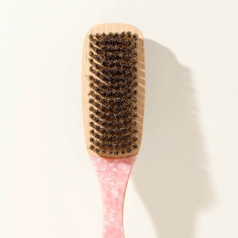 Brosse à cheveux lissante Pixie Woo pour des cheveux soyeux et parfaitement coiffés, visible avec poils en contact avec les cheveux.