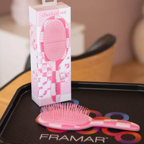 Brosse démêlante Framar Checked Out rose, outil de coiffure avec poils flexibles pour démêler en douceur.