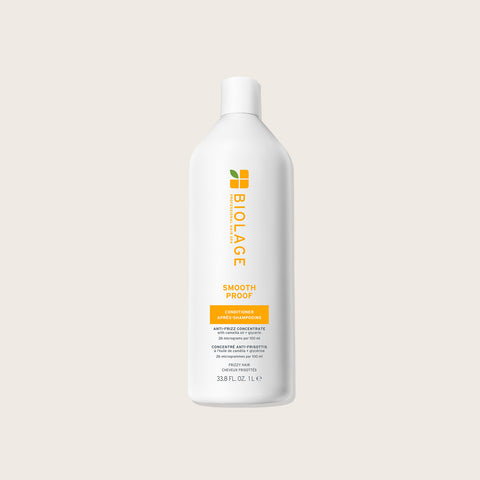 Revitalisant lissant pour cheveux Biolage Smooth Proof, texture crémeuse, bouteille verte avec étiquette.