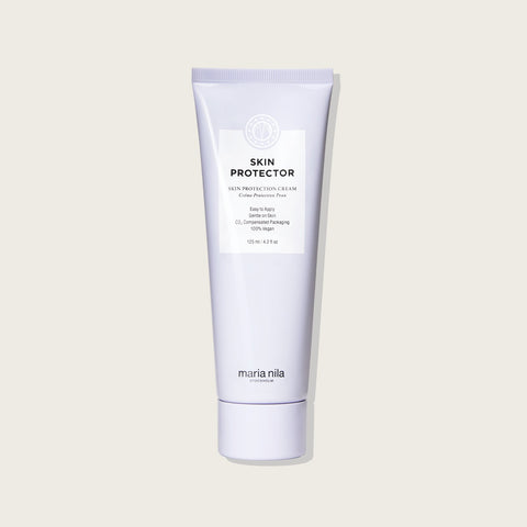 Crème protectrice Maria Nila Skin Protector 125 ml, tube blanc avec logo noir, pour protéger la peau.