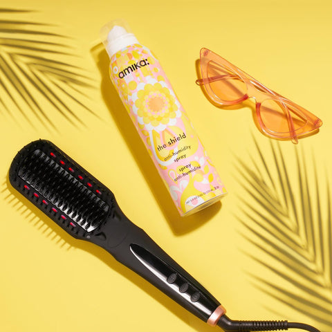 Spray anti-humidité Amika The Shield pour cheveux, flacon spray noir avec bouchon en plastique, protection contre l'humidité.