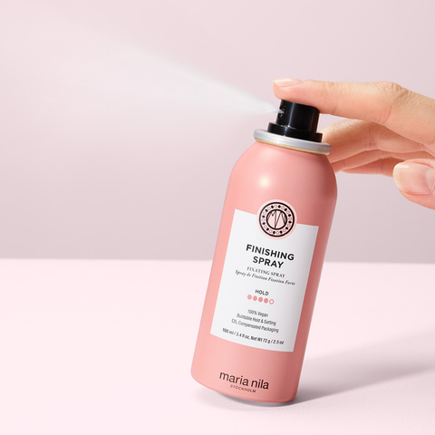 Spray de finition forte Maria Nila pour cheveux, flacon spray noir avec capuchon transparent, fixation durable.