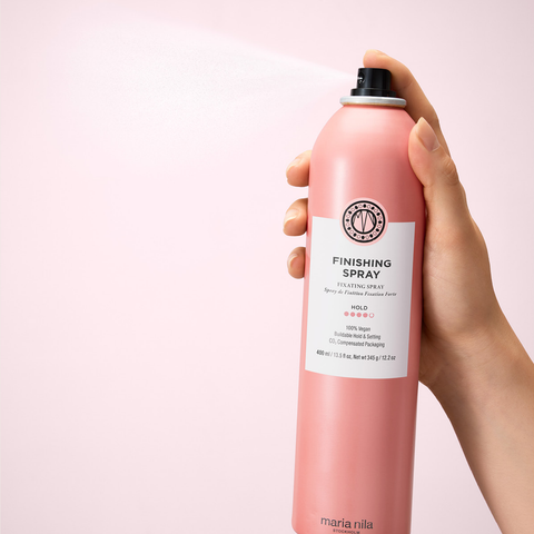 Spray de fixation forte Maria Nila pour cheveux, finition brillante, flacon spray noir avec logo blanc.