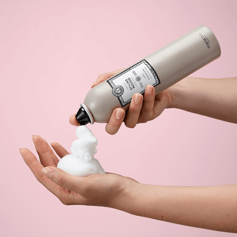 Mousse coiffante Maria Nila pour cheveux, texture légère et volumisante, visible dans le flacon avec bouchon blanc.