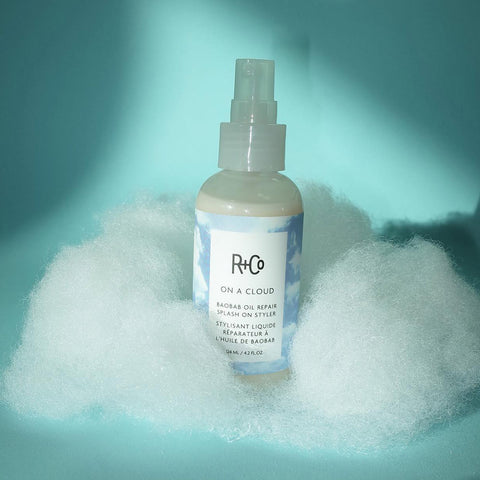 Soin capillaire réparateur R+Co On A Cloud en spray de 119 ml, texture légère pour cheveux doux et revitalisés.