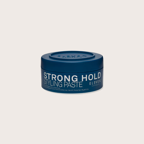 Pâte coiffante forte Eleven Australia pour cheveux, tube de 85 ml, texture épaisse et fixation ferme visible dans l'image.