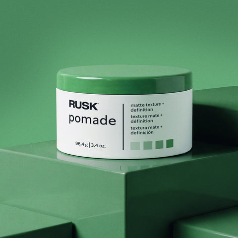 Pomade mate pour cheveux Rusk, texture naturelle, 100 ml, contenant une boîte de pomade avec un style moderne et texturé.