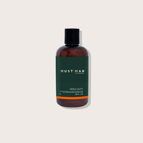 Shampooing triple action Must Man Professional pour cheveux, barbe et corps, flacon de 250 ml avec étiquette bleue.