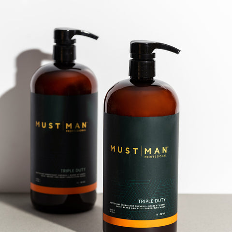 Shampooing triple duty Must Man Professionnel pour cheveux, barbe et corps, flacon en litre, bouteille avec étiquette blanche et bleue