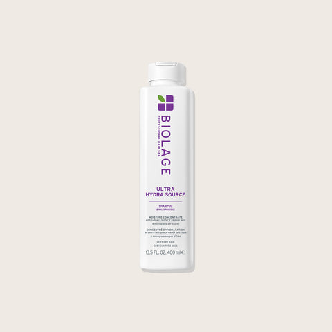 Shampoing hydratant Biolage Ultra Hydra Source pour cheveux, texture crémeuse et bouteille blanche avec logo Biolage.