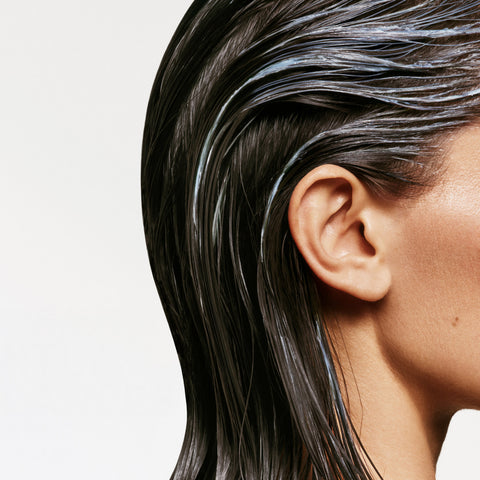 Shampooing anti-pelliculaire Biolage Scalp Sync pour cheveux, bouteille blanche avec étiquette verte, visible en gros plan.
