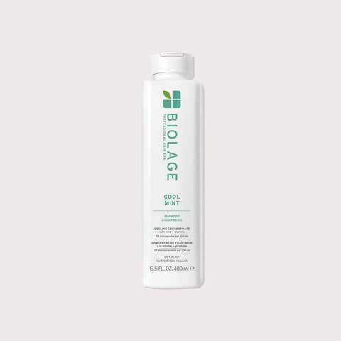 Shampooing Biolage Scalp Sync Cool Mint pour cheveux, flacon avec étiquette verte et texture visible dans le flacon.