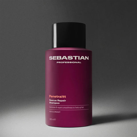 Shampooing réparateur Sebastian Penetraitt pour cheveux abîmés, bouteille blanche avec logo Sebastian, texture crémeuse visible.