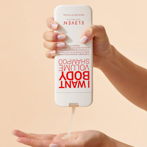 Shampooing volume Eleven Australia I Want Body pour cheveux, bouteille avec étiquette colorée, texture de shampooing.