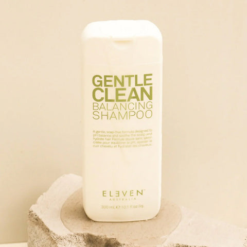 Shampooing équilibrant pour cheveux Eleven Australia, texture douce et nettoyante, bouteille blanche avec logo noir et vert.
