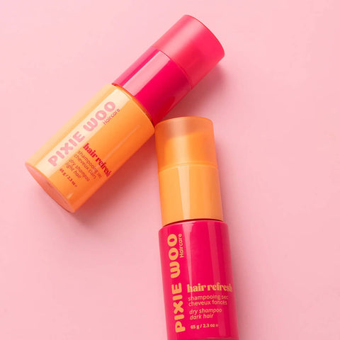 Shampooing sec pour cheveux foncés Pixie Woo de 65 g, flacon blanc avec étiquette, prêt à être utilisé pour rafraîchir les cheveux.