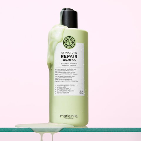 Shampooing structure réparateur Maria Nila pour cheveux, bouteille blanche avec logo rose et capuchon noir.