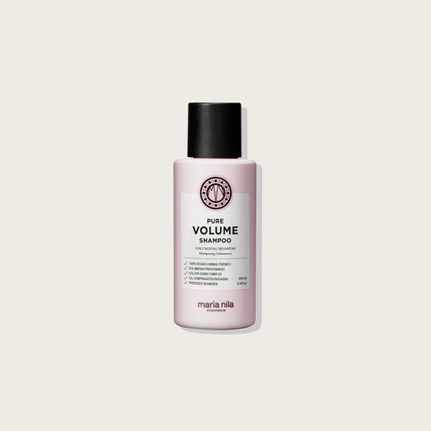 Shampooing volume Maria Nila Pure Volume pour cheveux volumineux, bouteille blanche avec étiquette colorée, en gros plan.
