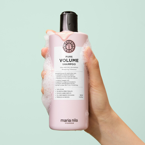 Shampooing volume Maria Nila Pure Volume pour cheveux, bouteille rose avec étiquette blanche et bouchon noir.