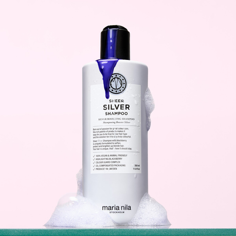 Shampooing neutralisant Sheer Silver de Maria Nila pour cheveux blonds ou gris, en bouteille avec étiquette violette et argentée.