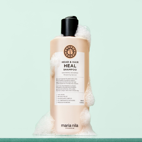 Shampooing apaisant pour cheveux Maria Nila Head & Hair Heal, bouteille blanche avec étiquette bleue et logo de la marque.