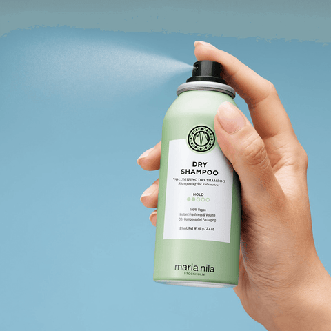 Spray sec volumisant Maria Nila pour cheveux, flacon blanc avec étiquette, prêt à rafraîchir et donner du volume aux cheveux.