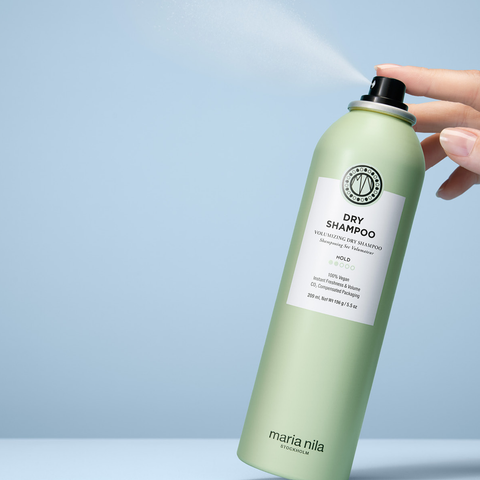Spray sec volumisant Maria Nila pour cheveux, bouteille blanche avec logo noir, idéal pour rafraîchir la coiffure.