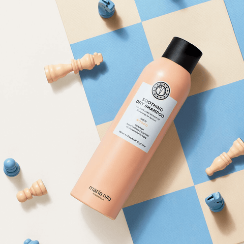 Shampooing sec apaisant Maria Nila pour cheveux secs, bouteille blanche avec étiquettes vertes et détails de produit visible