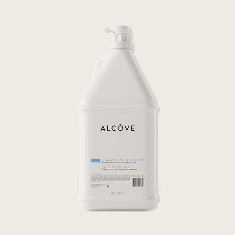 Shampooing hydratant pour cheveux Alcôve dans une bouteille blanche avec étiquette bleue et logo.