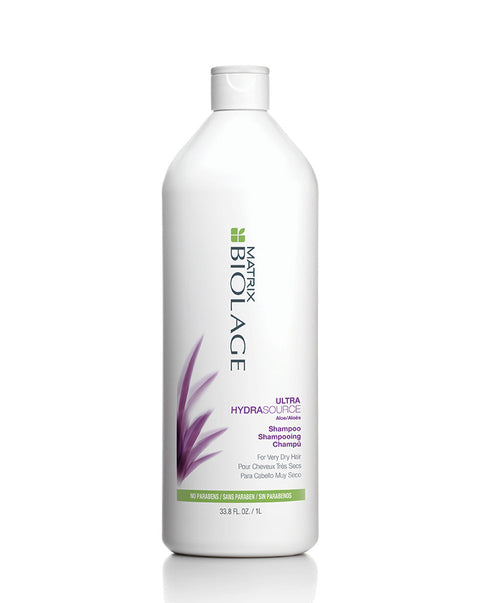 Shampooing hydratant Biolage Ultra Hydra Source pour cheveux, bouteille avec étiquette bleue et texture crémeuse visible.
