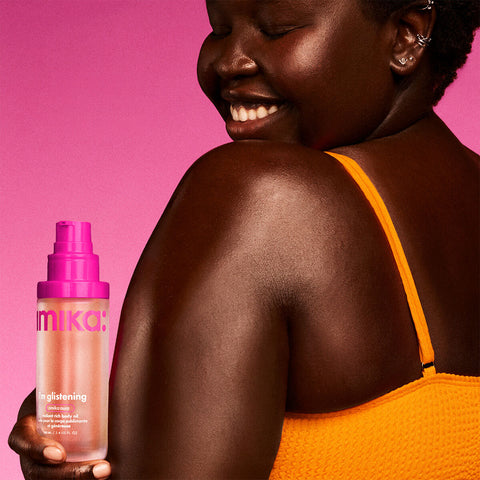 Huile pour le corps Amika I'm Glistening, 100 ml, en flacon avec texture brillante et packaging élégant.