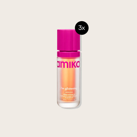 Huile pour le corps Amika I'm Glistening, offre spéciale 3x, texture brillante et hydratante, visible dans l'image.