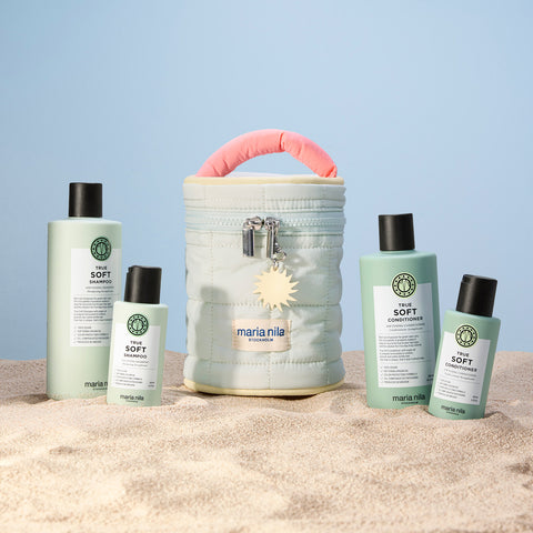 Trousse de beauté Maria Nila True Soft pour cheveux, contenant des produits capillaires dans une pochette élégante.